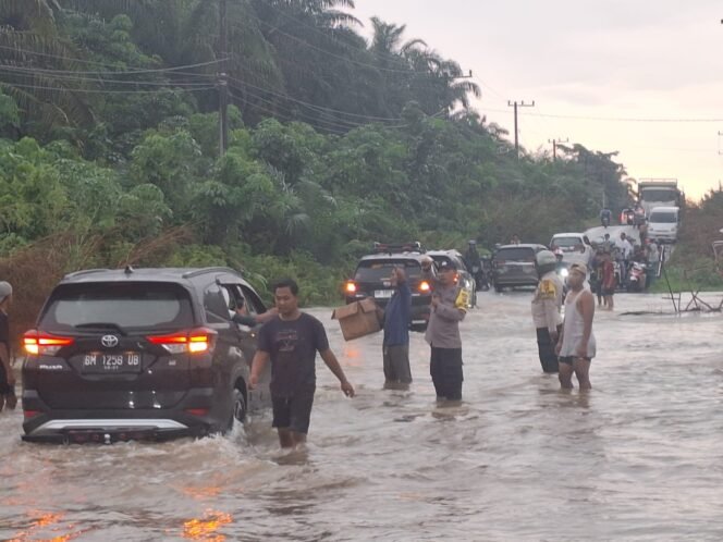 
					Curah Hujan Tinggi, Banjir Genangi Jalan Lintas Sumatra di Kecamatan Rambah Hilir.