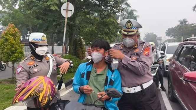 
Polisi Bersama Masyarakat Ditlantas Polda Riau Bagikan Masker